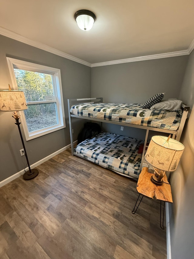bedroom with baseboards, wood finished floors, and crown molding