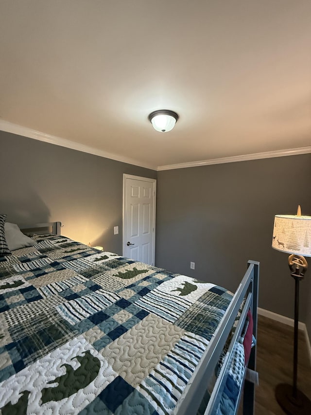 bedroom featuring wood finished floors, baseboards, and ornamental molding