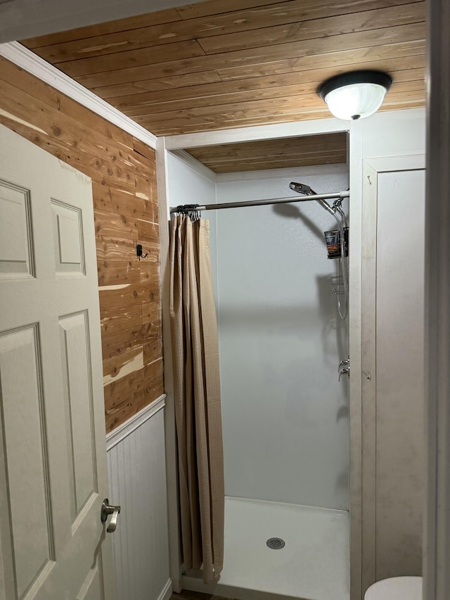 full bathroom with wood ceiling, toilet, wooden walls, and a stall shower
