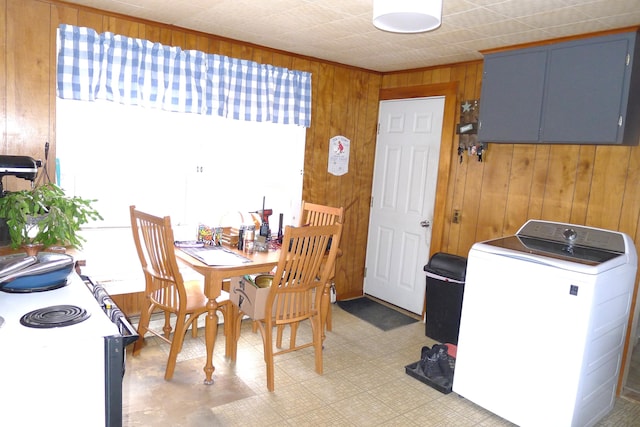 interior space featuring washer / dryer, wooden walls, and light floors
