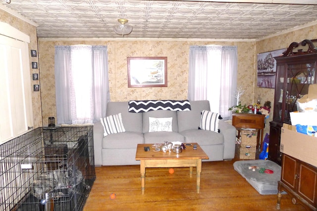 living area with wallpapered walls, a wealth of natural light, ornamental molding, and an ornate ceiling