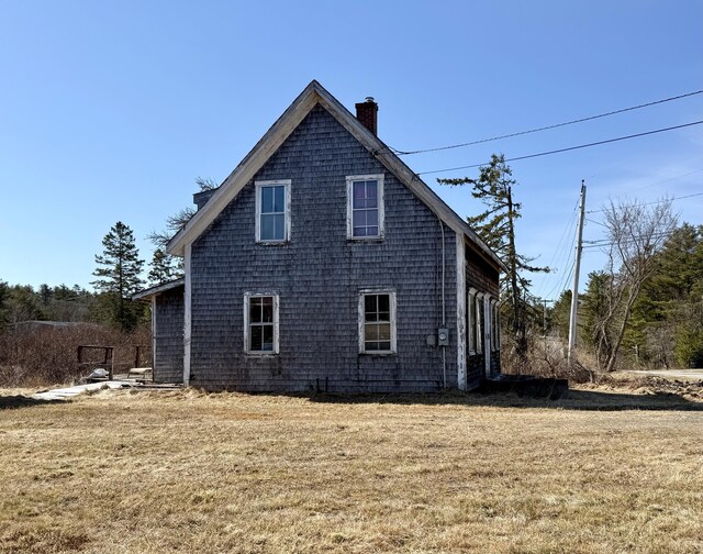 view of property exterior with a lawn and a chimney