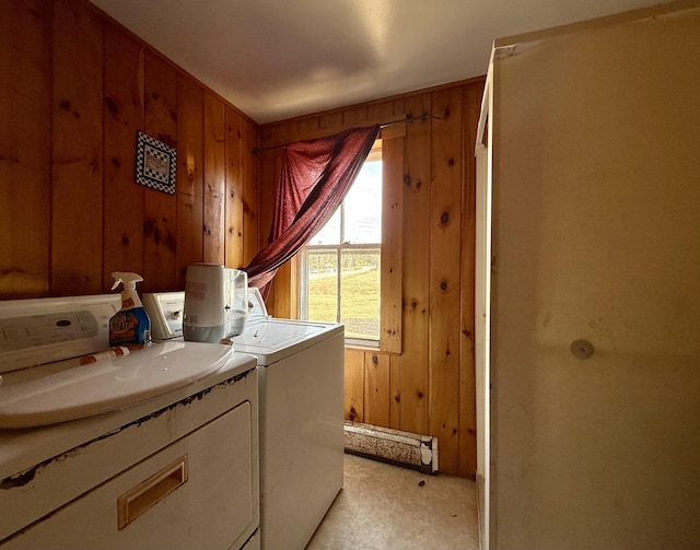 laundry area featuring wood walls, washer and clothes dryer, and laundry area