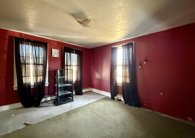carpeted empty room featuring baseboard heating, a baseboard radiator, baseboards, and a wood stove