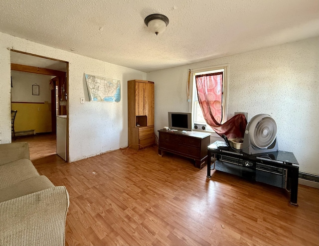 interior space with a textured wall, a textured ceiling, and light wood-style flooring