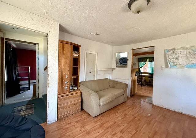 living area with light wood finished floors and a textured ceiling