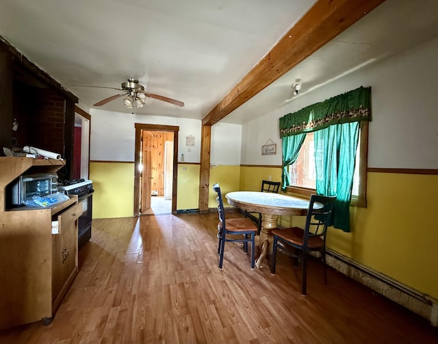 dining area featuring a ceiling fan, wood finished floors, beam ceiling, and a baseboard radiator