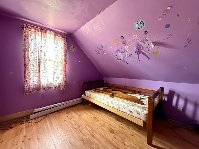 bedroom with a baseboard heating unit, vaulted ceiling, and wood finished floors