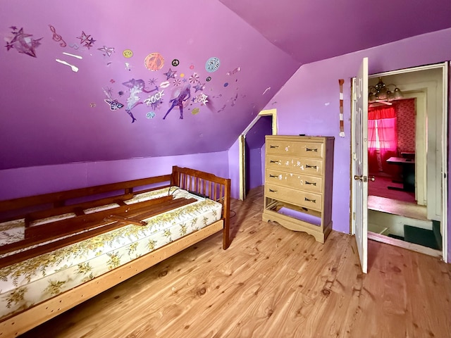 bedroom with lofted ceiling and wood finished floors