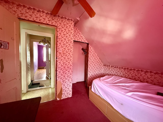 bedroom with wallpapered walls, vaulted ceiling, carpet floors, and ceiling fan