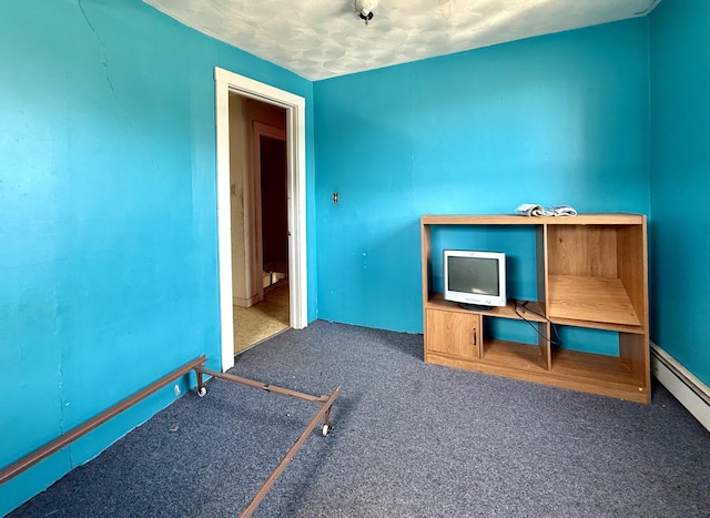 interior space with a baseboard heating unit and carpet