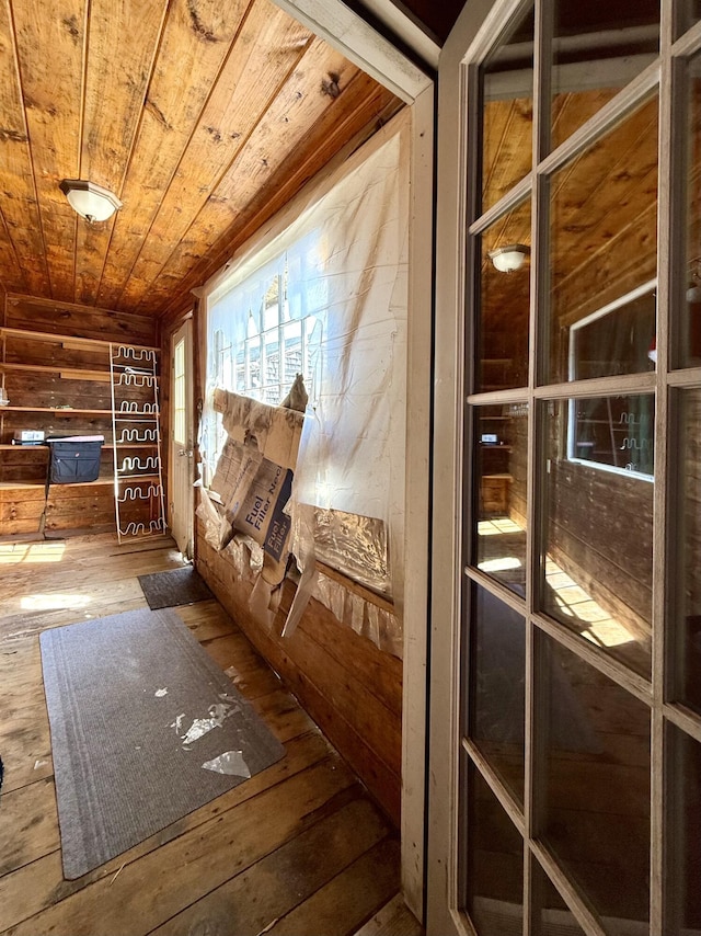 interior space featuring wooden ceiling, wood walls, and hardwood / wood-style floors