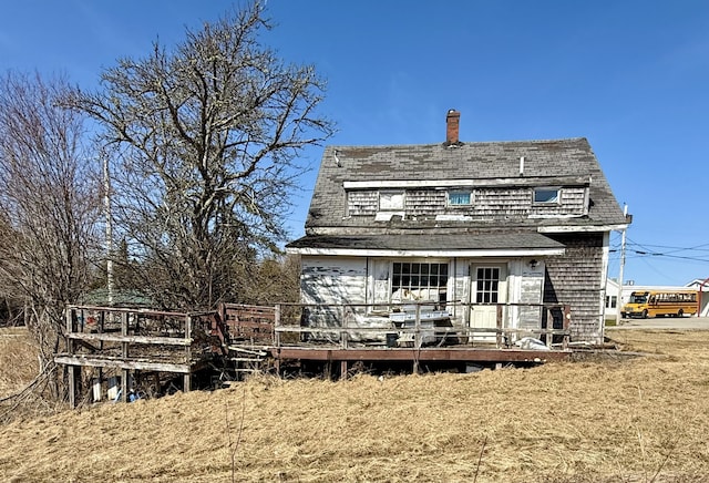 rear view of property with a chimney and a deck
