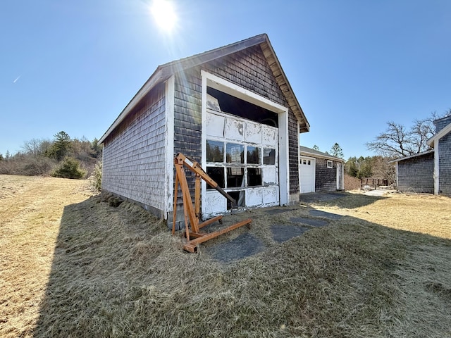 rear view of property featuring a garage and an outdoor structure