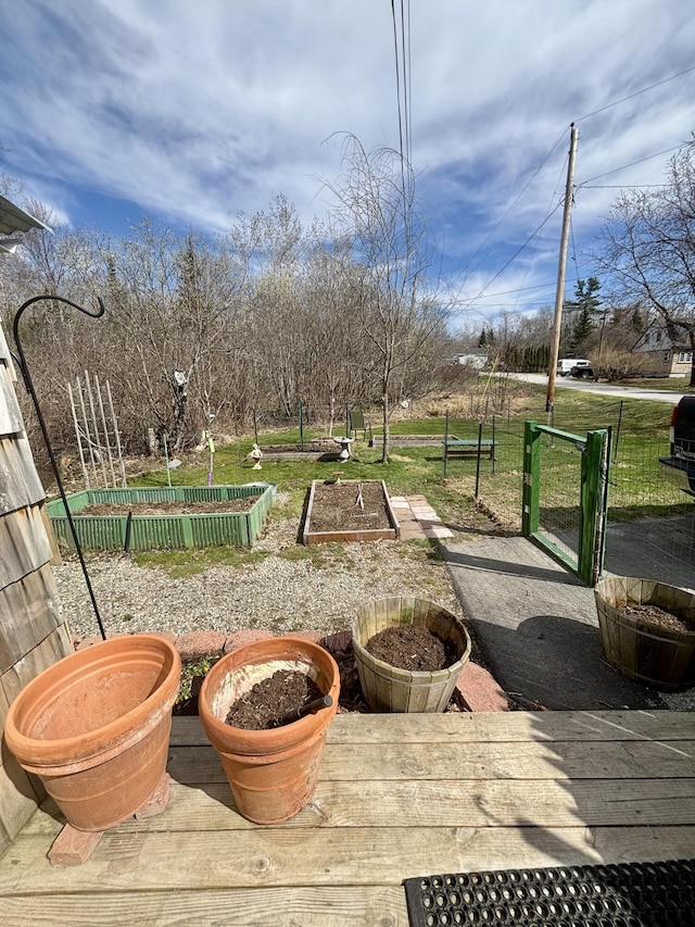 surrounding community featuring a lawn, fence, and a garden