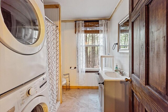 37 Torsey Shores Rd, Readfield, ME 04355 - bathroom with stacked washer / dryer, toilet, vanity, marble finish floors, and baseboards