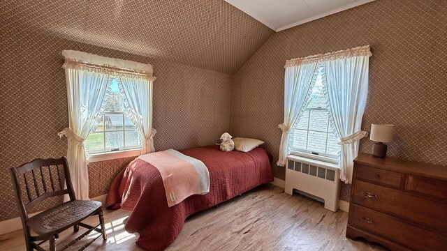 812 County Rd, Lubec, ME 04652 - bedroom featuring radiator, wallpapered walls, light wood-type flooring, and vaulted ceiling