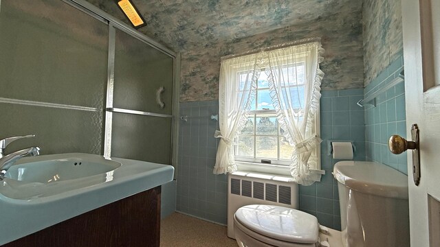 812 County Rd, Lubec, ME 04652 - full bath featuring radiator heating unit, tile walls, toilet, a shower stall, and vanity