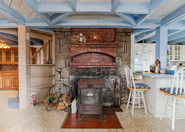 84 Hillside Rd, Westbrook, ME 04092 - unfurnished living room with tile patterned floors, a wood stove, and beam ceiling