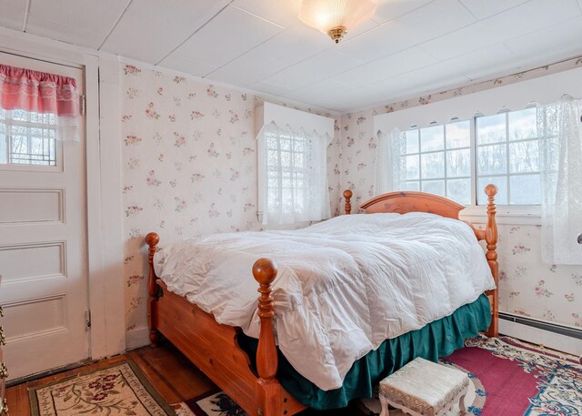 84 Hillside Rd, Westbrook, ME 04092 - bedroom featuring a baseboard heating unit, wallpapered walls, and wood finished floors