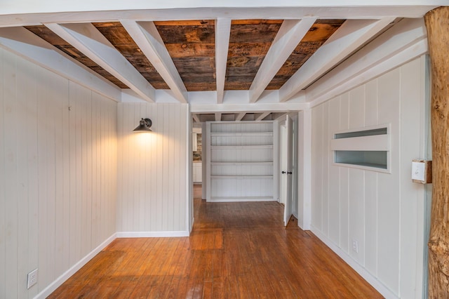 hall with wood walls, baseboards, beamed ceiling, and wood-type flooring