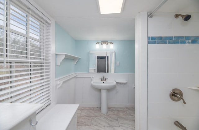 bathroom with wainscoting, a sink, a shower, and marble finish floor
