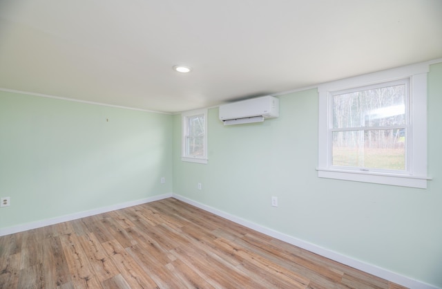 interior space featuring light wood-style floors, recessed lighting, a wall mounted AC, and baseboards