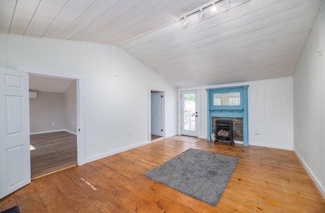 unfurnished living room featuring wooden ceiling, track lighting, vaulted ceiling, light wood-style flooring, and baseboards
