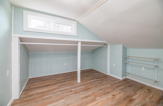 additional living space featuring baseboards, wood finished floors, and vaulted ceiling