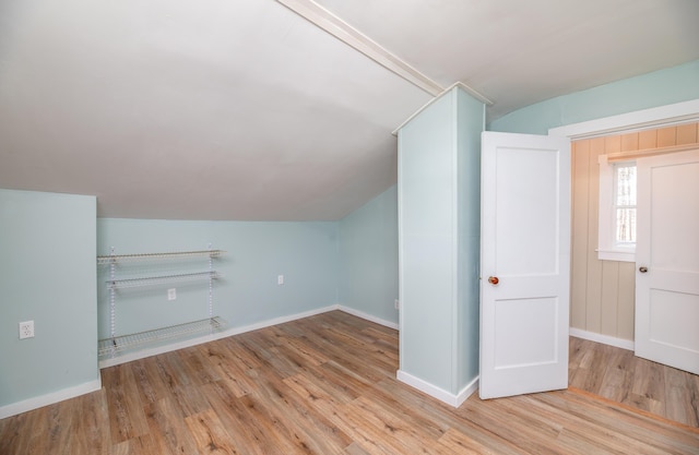 bonus room with wood finished floors, vaulted ceiling, and baseboards