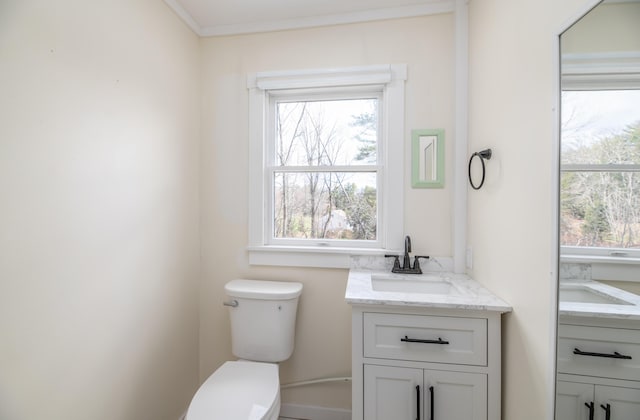 bathroom featuring toilet, vanity, and a healthy amount of sunlight