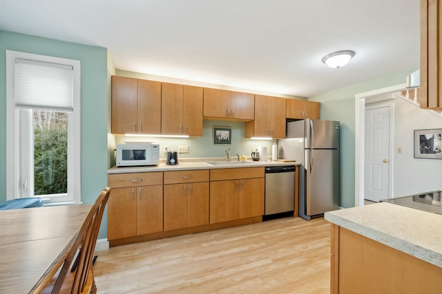 12 Ephraim Tyler Way Unit 12, Kennebunk, ME 04043 - kitchen with stainless steel appliances, a sink, light wood finished floors, and light countertops