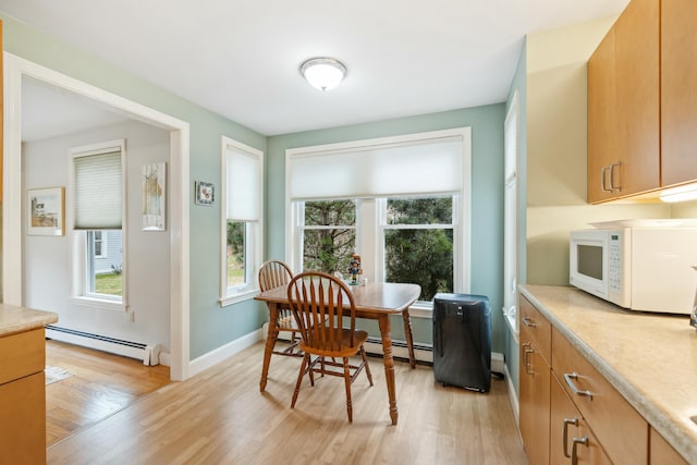 12 Ephraim Tyler Way Unit 12, Kennebunk, ME 04043 - dining space with baseboard heating, light wood-style flooring, and plenty of natural light