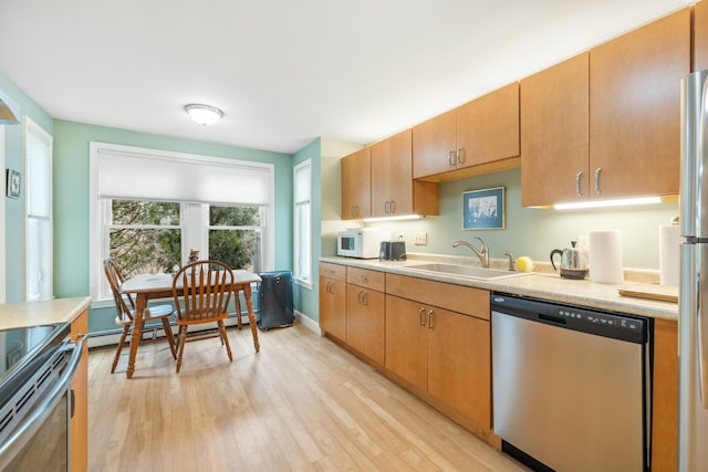 12 Ephraim Tyler Way Unit 12, Kennebunk, ME 04043 - kitchen with appliances with stainless steel finishes, a sink, a baseboard heating unit, light countertops, and light wood-style floors