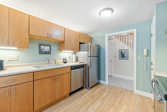 12 Ephraim Tyler Way Unit 12, Kennebunk, ME 04043 - kitchen with appliances with stainless steel finishes, a sink, light countertops, light wood-style flooring, and baseboards