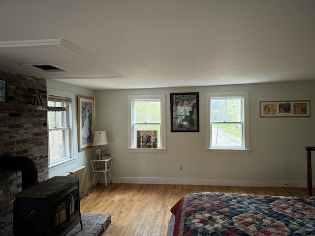 14 Ash Swamp Rd, Scarborough, ME 04074 - bedroom featuring a wood stove, multiple windows, radiator, and light wood-style floors
