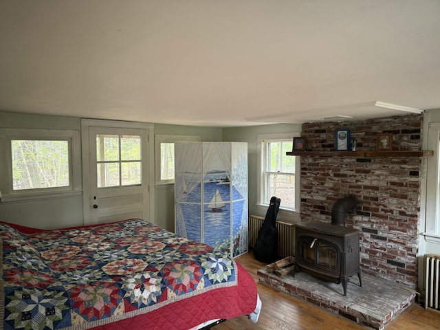 14 Ash Swamp Rd, Scarborough, ME 04074 - bedroom with a wood stove, radiator heating unit, and wood finished floors