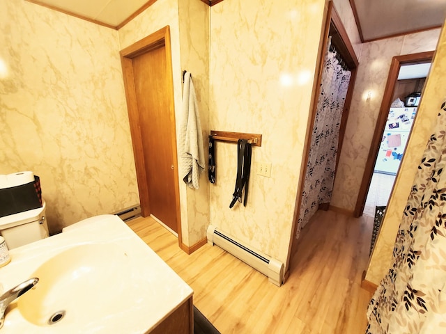 9 Locust St, Madison, ME 04950 - bathroom featuring crown molding, wood finished floors, baseboard heating, and a baseboard heating unit