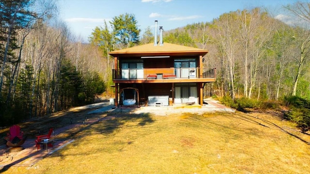 back of house featuring a view of trees