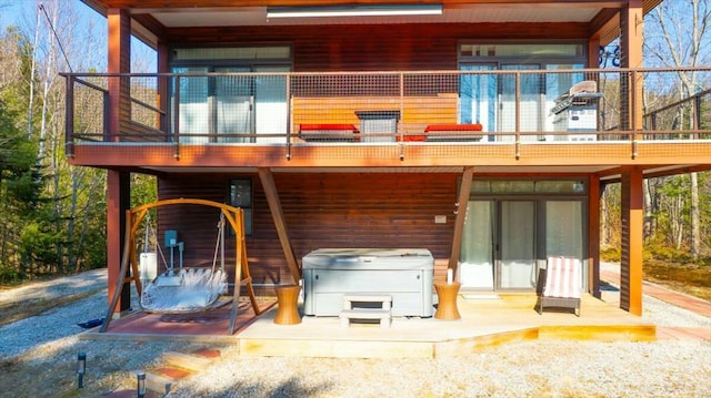 rear view of house with a hot tub