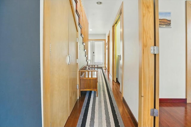 corridor with baseboards and dark wood-style flooring