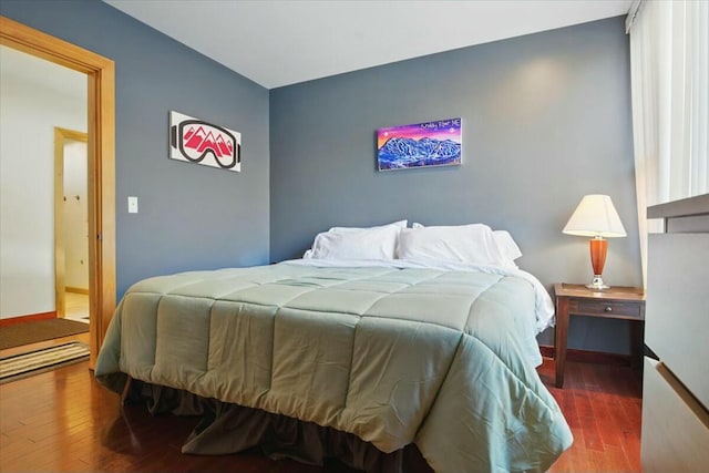 bedroom with baseboards and wood finished floors