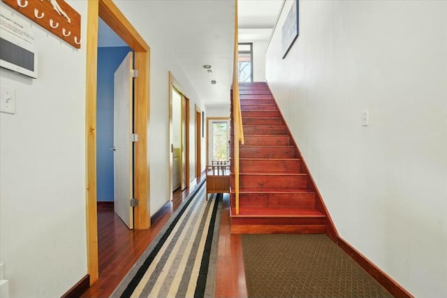 stairs featuring wood finished floors and baseboards