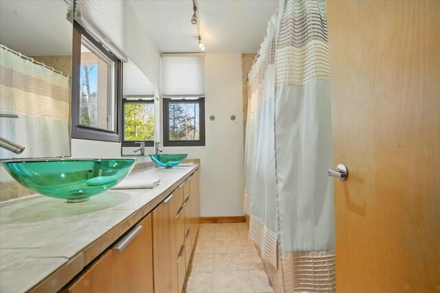 bathroom featuring track lighting, tile patterned flooring, and vanity