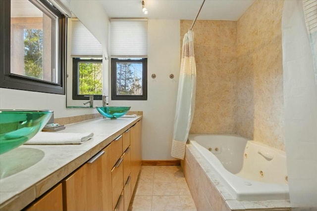 bathroom featuring tile patterned floors, a sink, double vanity, baseboards, and a combined bath / shower with jetted tub