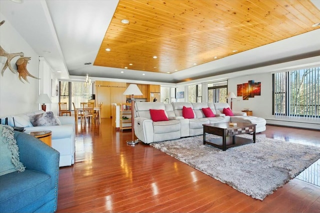 living room featuring recessed lighting, a raised ceiling, wood finished floors, wood ceiling, and baseboard heating