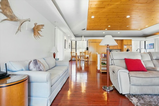 living room featuring wood finished floors, a tray ceiling, and recessed lighting