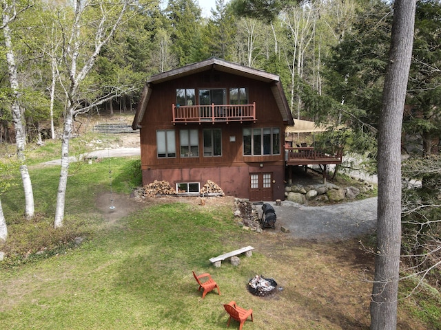 823 Grindstone Rd, Medway, ME 04460 - view of front facade featuring a front yard, a forest view, a balcony, and a wooden deck