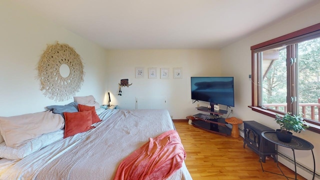 823 Grindstone Rd, Medway, ME 04460 - bedroom with a baseboard heating unit, multiple windows, and wood finished floors