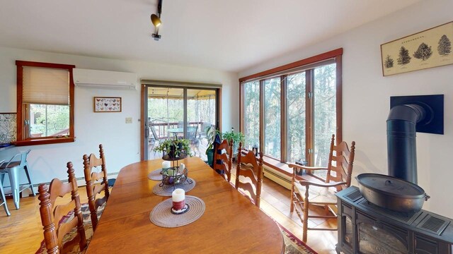 823 Grindstone Rd, Medway, ME 04460 - dining area with a wall mounted air conditioner and a wood stove